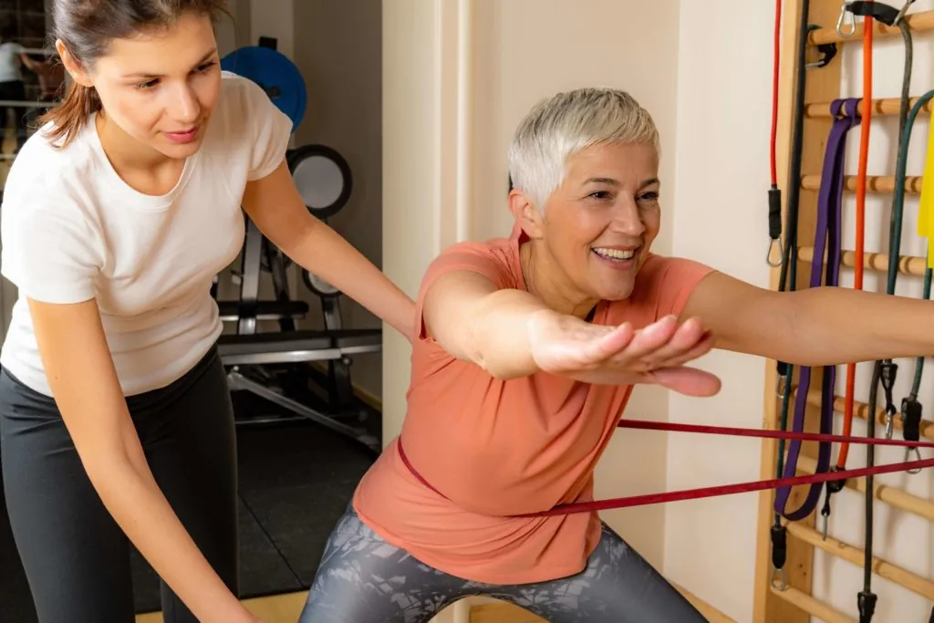 elderly woman working on fall prevention in physical therapy